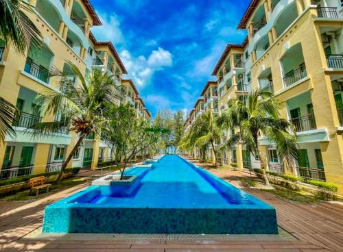 a swimming pool in front of a building at Tiara Desaru beach stay in Bandar Penawar