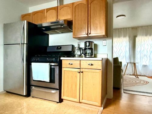 a kitchen with a stainless steel refrigerator and wooden cabinets at Cozy Coastal by Beaches & Redwoods in McKinleyville