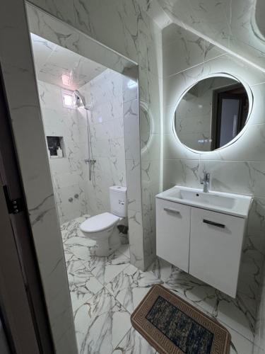 a bathroom with a sink and a toilet and a mirror at Rooftop apartments in Taghazout