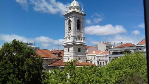 a tall white clock tower in a city at Fisher 46 in Lisbon