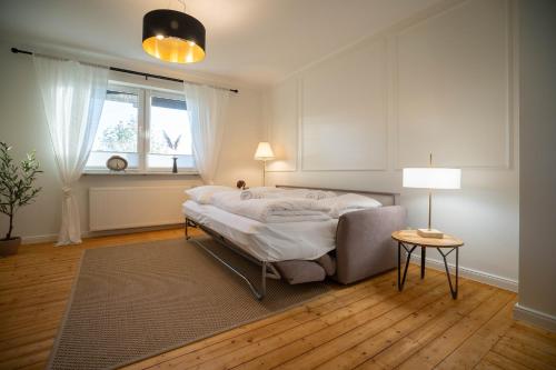 a bedroom with a bed and a table and a window at Ferienwohnung - Ewigkeit in Minden