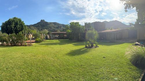 een tuin met een groen gazon met een huis bij Casa Evelia in Tepoztlán