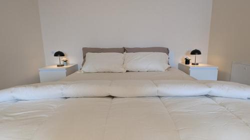 - un grand lit blanc avec 2 tables de chevet et 2 lampes dans l'établissement Viator Vale, à Tremosine