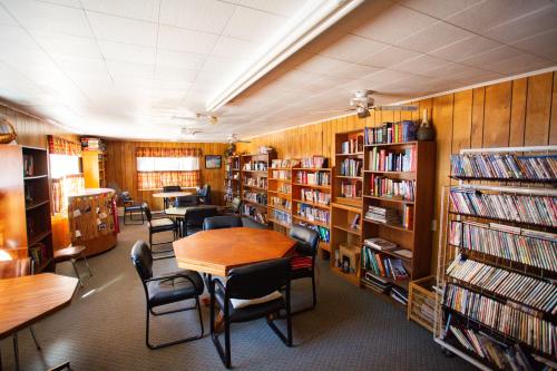 a library with several tables and chairs and bookshelves at JW Vallecito in Vallecito