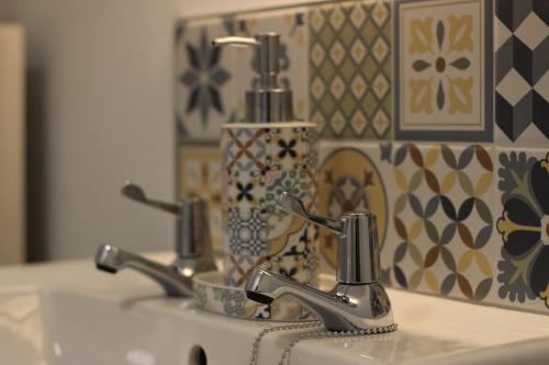 ein Waschbecken mit zwei Armaturen und einem Spiegel in der Unterkunft Kings Corner in Warrenpoint