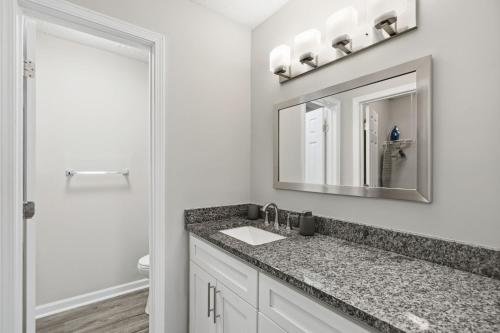une salle de bain avec un lavabo et un miroir dans l'établissement Crest At East Cobb 1828relaxing, Comfy 2bd 2bt, à Marietta