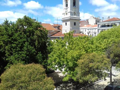 a building with a clock tower with trees in the foreground at Fisher 46 in Lisbon