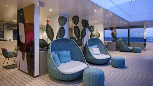 Una habitación con sillas azules en un crucero. en Iconix, en Freshwater Pond