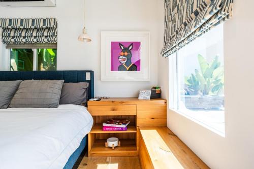 ein Schlafzimmer mit einem Bett und einem Nachttisch neben einem Fenster in der Unterkunft Simple La Jolla Epic bungalow # 3 in San Diego