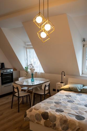 a bedroom with a bed and a table with chairs at Talvera Dream - City center, Rooftop, Garage & Jacuzzi in Bolzano