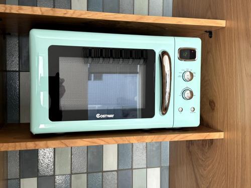 eine blaue Mikrowelle auf einem Holzregal in der Unterkunft Simple La Jolla Epic bungalow # 3 in San Diego