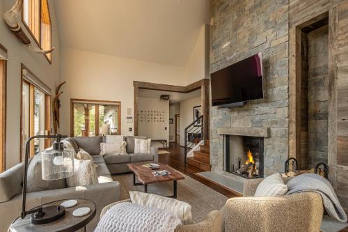 a living room with a stone fireplace at Southfork Retreat in Big Sky