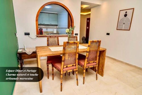 ein Esszimmer mit einem Holztisch und Stühlen in der Unterkunft Élégance Centrale Face TGV & à 5 min de la Mer in Tangier