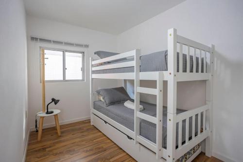 a white bunk bed in a room with a window at Hermoso duplex en Palermo in Montevideo
