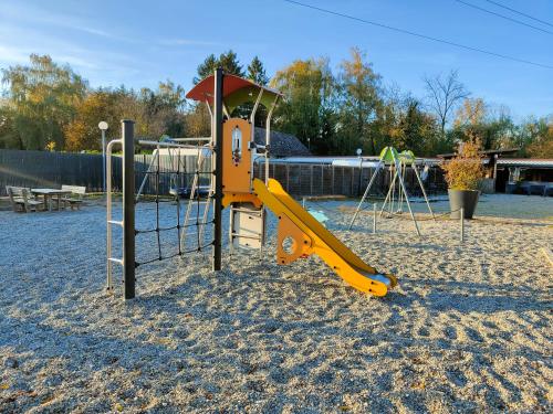 einen Spielplatz mit Rutsche im Sand in der Unterkunft La Petite Maison du Park in Boofzheim