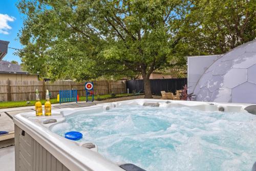 uma banheira de hidromassagem com água num quintal em Luxe Family Escape with Games and Hot Tub and Yard em San Antonio