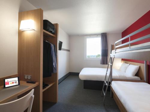 Habitación de hotel con 2 camas y escritorio en B&B HOTEL Paray-le-Monial en Paray-le-Monial