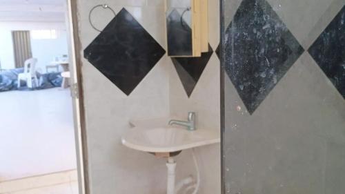 a bathroom with a sink and black triangles on the wall at Casa com 5 suítes e Churrasqueira para 12 pessoas in Atalaia