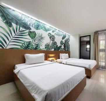 Un dormitorio con dos camas y un mural en la pared. en Indra Homs, 