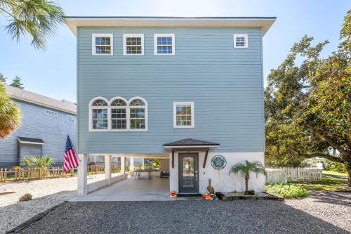 a blue house with a flag in front of it at The Sand Euro - 4BR, 3Full & 1Half BA in Historic Summer Haven near beaches and Matanzas Inlet in Summer Haven