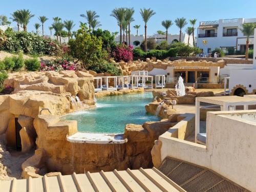 a swimming pool with a waterfall in a resort at Oasis Domina Coral Bay in Sharm El Sheikh