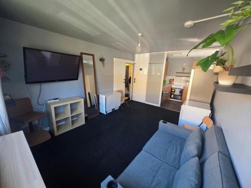 ein Wohnzimmer mit einem blauen Sofa und einem Flachbild-TV in der Unterkunft A home in the city in London