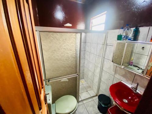 a small bathroom with a shower and a red sink at house for cop30 in val-de-cans in Belém