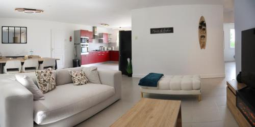 een woonkamer met een witte bank en een tafel bij Mon havre de paix, Villa Campagne Charentaise in Mansle