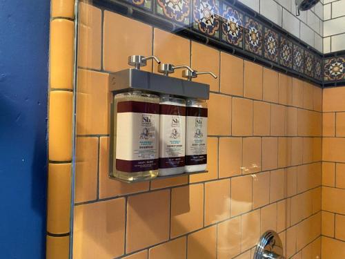 Un baño con dos botellas de pintura en una pared de azulejos. en West Beach Villa 5, en Santa Bárbara
