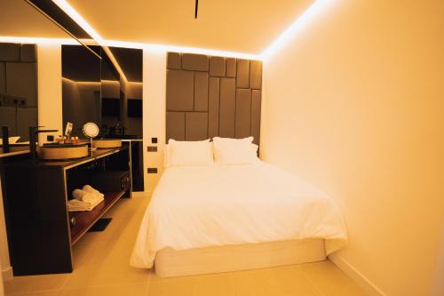 a bedroom with a white bed and a sink at Petit Suite in Valle Gran Rey