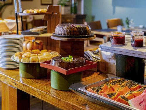 a buffet line with various types of food on a table at Mercure Sao Paulo Moema Times Square in Sao Paulo