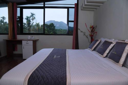 Un dormitorio con una cama grande con una ventana grande. en Mountain Vibes Wayanad Pool Villa and Spa, en Wayanad