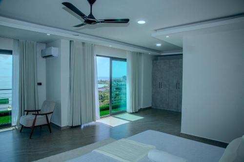 a bedroom with a bed and a chair and windows at Semo's Aqua luxury 6 bedrooms Penthouse sea views in Mombasa