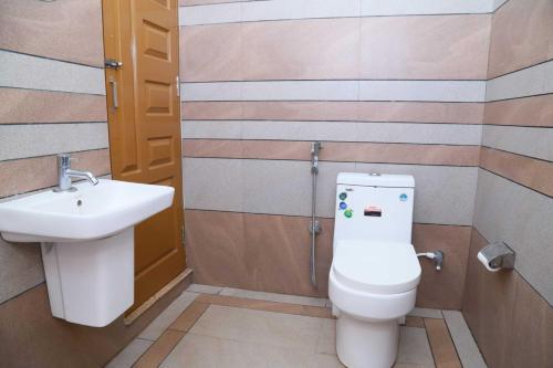 un baño con inodoro y lavabo en Mountain Vibes Wayanad Pool Villa and Spa, en Wayanad