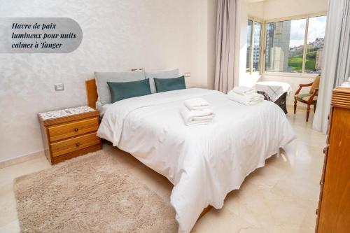 a bedroom with a large bed with towels on it at Royal Chic Centre-Ville & Plage à 5 min in Tangier