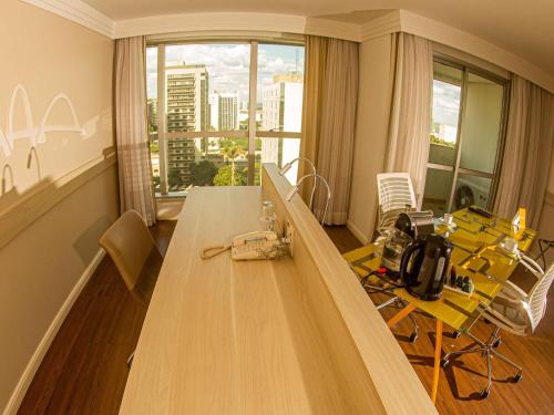 a room with a long table with a view of a city at Mercure Brasilia Lider in Brasilia