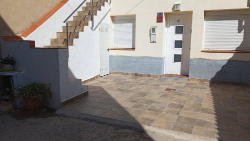 a building with a stairway next to a house at Casa Luci in Sant Jaume d'Enveja