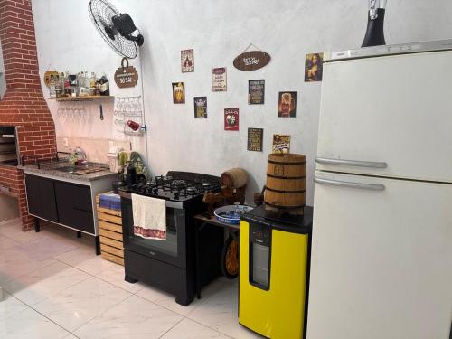 een keuken met een fornuis en een koelkast bij Chácara embaixador in Hortolândia