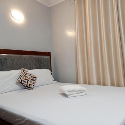 Ongata Rongai にあるFara Luxury homesのベッドとタオル2枚のある寝室