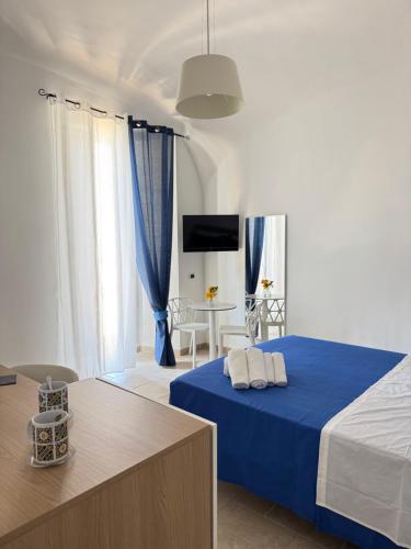 a bedroom with a blue bed and a table at Sea Vibes I FLOOR in Portici