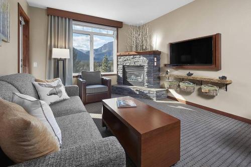 a living room with a couch and a fireplace at Mountain View Escape with open hot tub, Views!! in Canmore