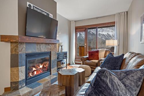 a living room with a fireplace and a tv at RidgeView Loft - Top Floor 2 Bed 2 Bath, Amazing Views in Canmore
