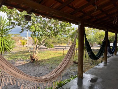 a hammock with a view of a park at Recanto Caiçara Caraiva - Chalé, Quartos privativos e Compartilhado in Porto Seguro