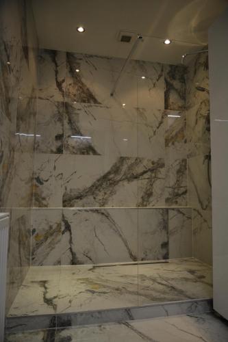 a bathroom with a marble shower with a glass wall at Apartmán Alex, Nezábudka in Tatranska Strba