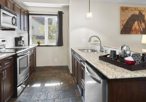 a kitchen with a sink and a counter top at Sundance Suite - Beautiful Condo With Open Pool And Hot Tub in Canmore