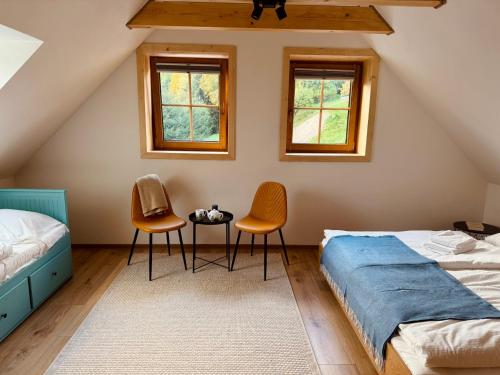 un dormitorio con dos camas y dos sillas en Chata pod Jabloňou, en Banská Štiavnica