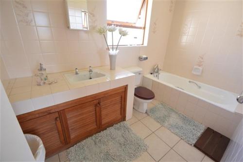 a bathroom with a tub and a sink and a bath tub at Laridae Getaway in Plettenberg Bay