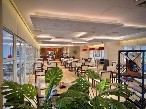 a dining room with tables and chairs and plants at Novotel Santiago Vitacura in Santiago