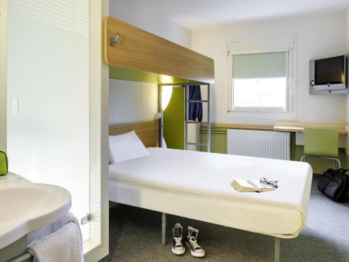 a hotel room with a bed and a sink and a bed sidx sidx at ibis budget Hotel Brussels Airport in Diegem