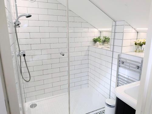 a white bathroom with a shower and a sink at Old Yarn Apartment - Close to city walls in York